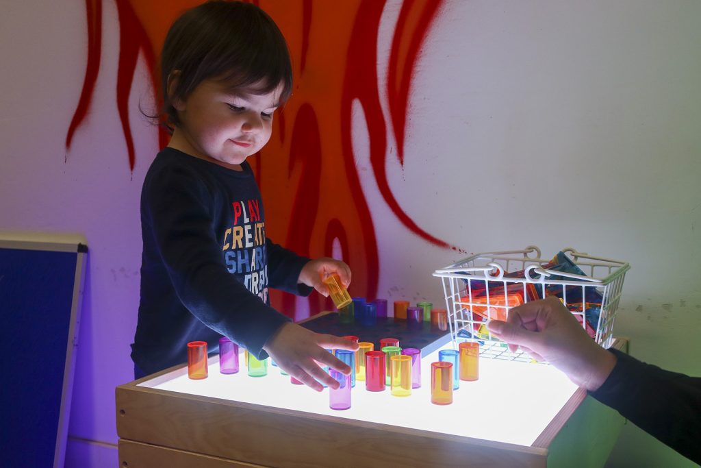 little boy playing with light up toys