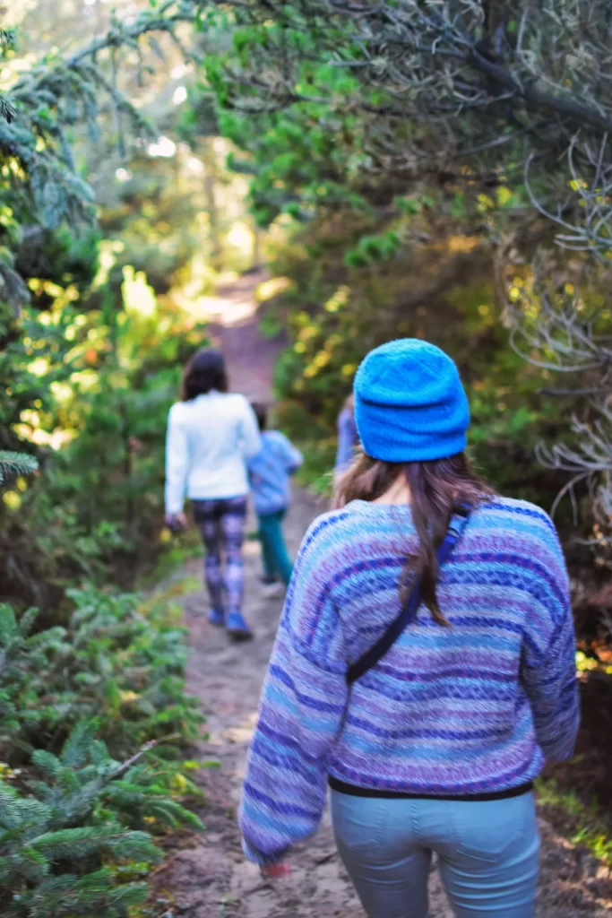 2 women and a child walking along a forest trail