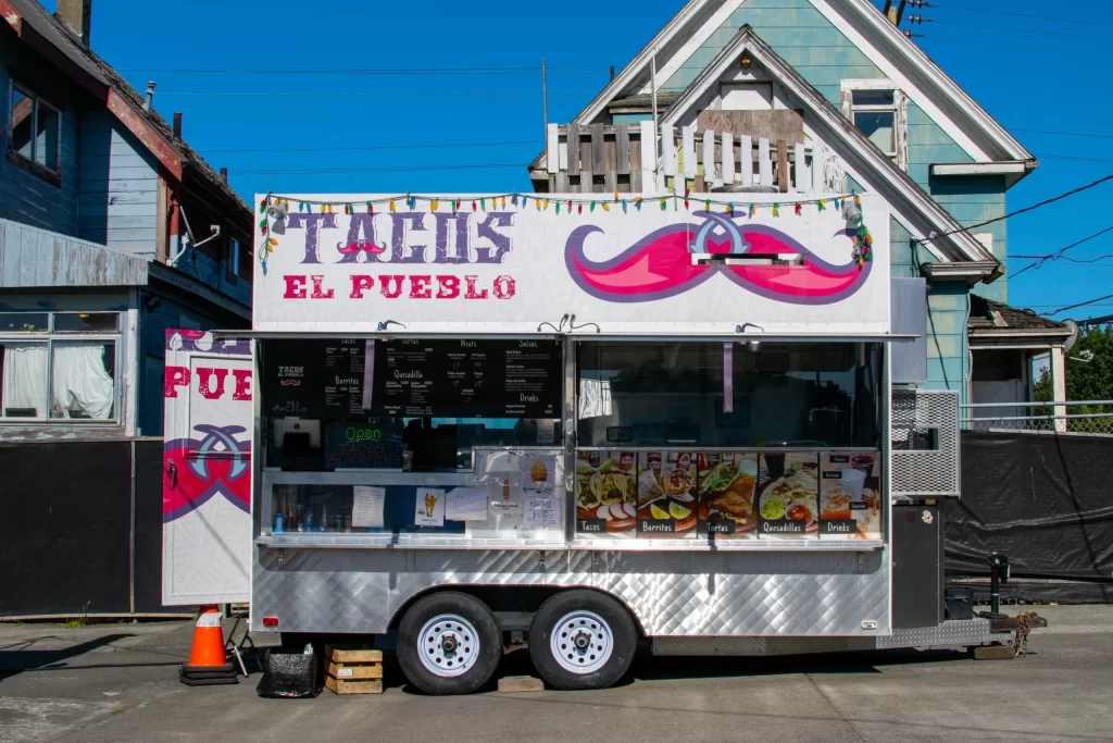 Taco food truck open in front of houses